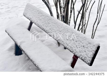 Wooden bench in the snow. Wooden bench in the snow. 142244375
