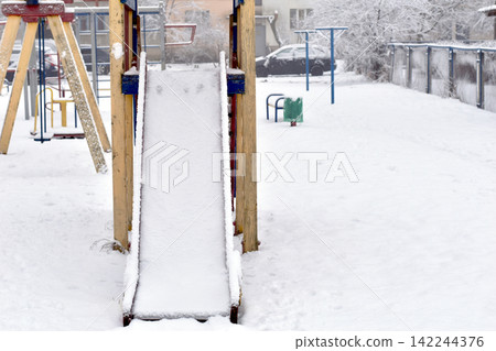 Children's playground covered in snow. Children's playground covered in snow. 142244376