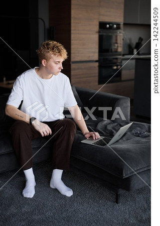 Thoughtful caucasian man planning day in modern kitchen lounge Thoughtful caucasian man planning day in modern kitchen lounge 142244509