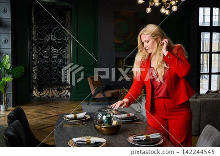 Stylish woman configuring upscale dining setup for editorial purposes Stylish woman configuring upscale dining setup for editorial purposes 142244545