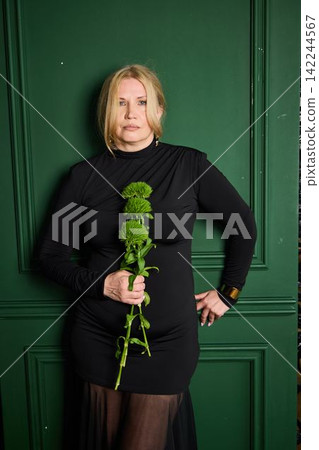 Determined white woman hand on hip holding green flowers 142244567