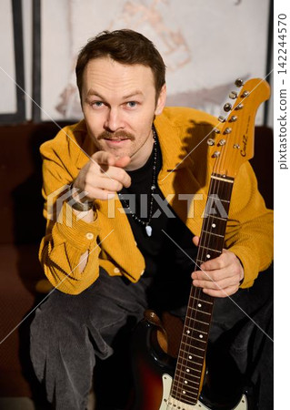 Musician enthusiastically points at camera to promote performance Musician enthusiastically points at camera to promote performance 142244570