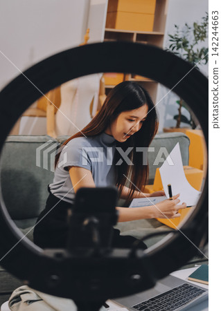 Woman recording live stream preparing packages for online selling Woman recording live stream preparing packages for online selling 142244663