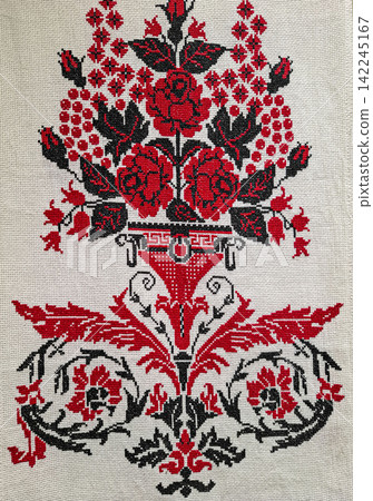 Traditional Slavic cross stitch artwork features red black flowers and a vase design on beige linen fabric Traditional Slavic cross stitch artwork features red black flowers and a vase design on beige linen fabric 142245167