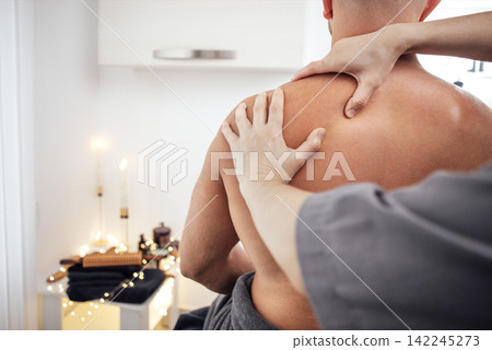 Male receiving therapeutic massage in a serene spa environment, with soft lighting and candles creating a relaxing atmosphere for wellness and rejuvenation 142245273