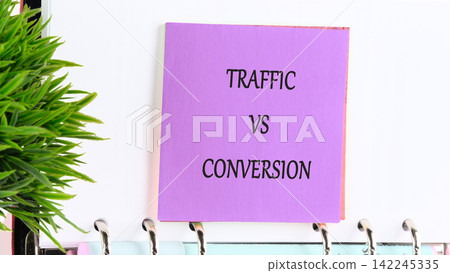 E-commerce business concept with Traffic vs Conversion text written on a purple sticky note attached to a spiral notebook 142245335