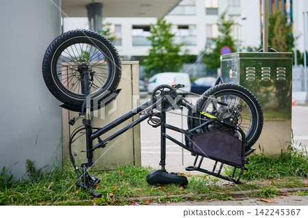 Broken electric fat bike with a flat tire lying upside down on the street Broken electric fat bike with a flat tire lying upside down on the street 142245367