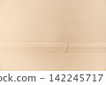 Interior wall with visible crack and molding detail, showcasing a light beige color scheme and smooth surface texture in a residential setting 142245717