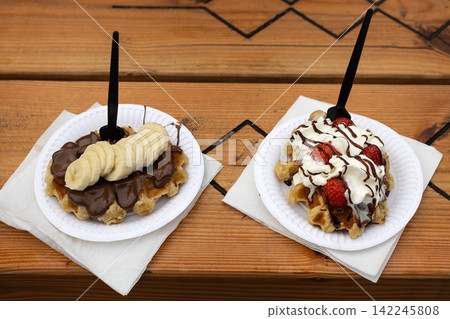 Pair of Belgian Liege Waffles with Banana and Strawberries 142245808