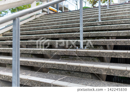 Architectural details of an outdoor staircase with a concrete railing. Architectural details of an outdoor staircase with a concrete railing. 142245830