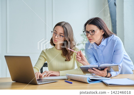 Female teacher helping young student during laptop study session Female teacher helping young student during laptop study session 142246018