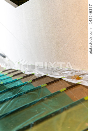 Staircase of a building covered in protective sheeting in preparation for painting work. Staircase of a building covered in protective sheeting in preparation for painting work. 142246357