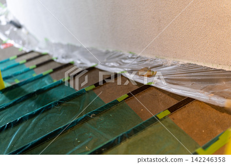 Staircase of a building covered in protective sheeting in preparation for painting work. Staircase of a building covered in protective sheeting in preparation for painting work. 142246358
