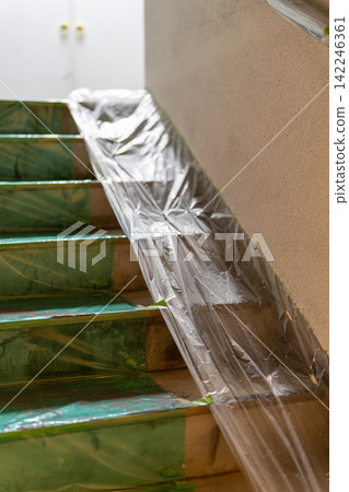 建築物樓梯上覆蓋著保護膜,準備進行油漆工作。 建築物樓梯上覆蓋著保護膜,準備進行油漆工作。 142246361