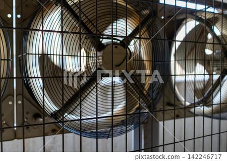 A machinery and equipment area lined with large industrial axial flow fans. A machinery and equipment area lined with large industrial axial flow fans. 142246717