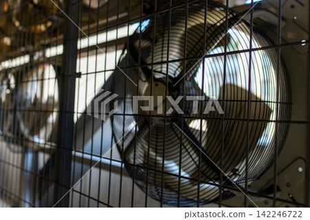 A machinery and equipment area lined with large industrial axial flow fans. A machinery and equipment area lined with large industrial axial flow fans. 142246722