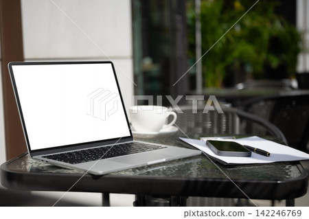 Freelancer workspace with laptop mockup and smartphone at outdoor cafe Freelancer workspace with laptop mockup and smartphone at outdoor cafe 142246769
