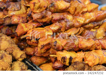 Barbecue grill. Grilled poultry kebab. Delicious shish kebab. Grilled BBQ. Skewer meat cooking on barbecue, rotisserie shashlik. Chicken meat on skewer. Chicken on BBQ grill. Street food 142247232