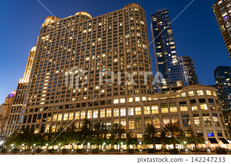Chicago night city. Skyscraper building architecture. Business skyscraper at night. Skyscraper in city downtown. City architecture. City night illuminated building. Modern glass building Chicago night city. Skyscraper building architecture. Business skyscraper at night. Skyscraper in city downtown. City architecture. City night illuminated building. Modern glass building 142247233