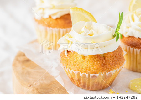 Lemon cupcakes topped with cream frosting and lemon Lemon cupcakes topped with cream frosting and lemon 142247282