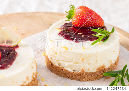 Mini berry cheesecakes topped with fresh strawberry Mini berry cheesecakes topped with fresh strawberry 142247284