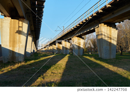 Serene corridor with shadowed columns and grassy surroundings Serene corridor with shadowed columns and grassy surroundings 142247708