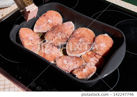 Beef steak slices seasoned with salt pepper herbs in baking tray, with beef, steak, meat, raw detail, showing uncooked, seasoning, salt, pepper context, with clear visible detail 142247746