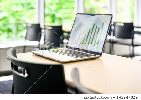 A laptop computer placed on the conference room table. A laptop computer placed on the conference room table. 142247829