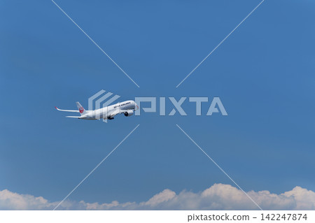 A passenger plane takes off into the clear summer sky. A passenger plane takes off into the clear summer sky. 142247874