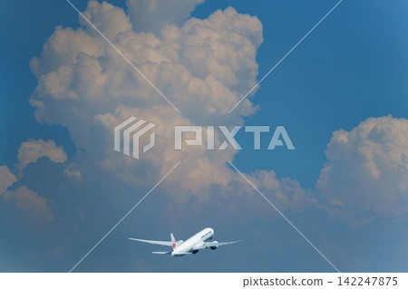 一架客機飛向夏日蔚藍的天空,巨大的積雨雲出現了。 一架客機飛向夏日蔚藍的天空,巨大的積雨雲出現了。 142247875