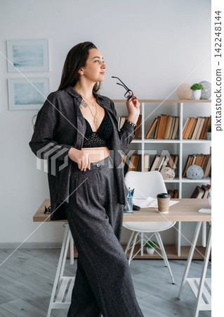 Female worker. Office routine. Stylish relaxed entrepreneur business professional at workplace with coffee document at desk indoor. Female worker. Office routine. Stylish relaxed entrepreneur business professional at workplace with coffee document at desk indoor. 142248144