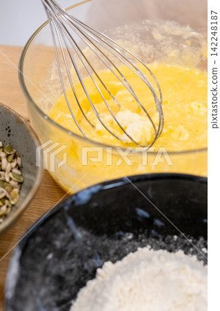 Cooking food. Whisking process. Mixing white wet ingredients batter for homemade pastry dough in glass bowl with culinary work tool. Cooking food. Whisking process. Mixing white wet ingredients batter for homemade pastry dough in glass bowl with culinary work tool. 142248187