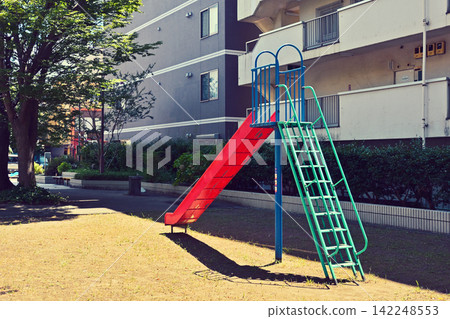 A slide in a park in town 142248553