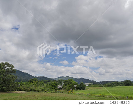 壯麗的夏日雲霧籠罩著綿延的山脈和寧靜的鄉村景色。 142249235