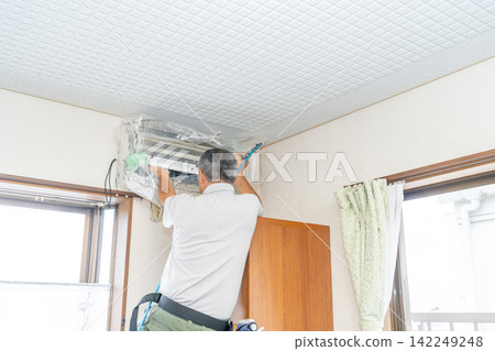 Air conditioner cleaning; a man from the air conditioner maintenance company. Air conditioner cleaning; a man from the air conditioner maintenance company. 142249248