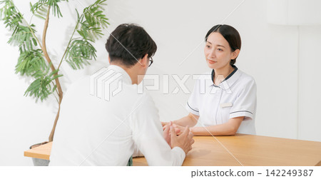 一位女診所接待員和一位男病人(橫幅) 一位女診所接待員和一位男病人(橫幅) 142249387