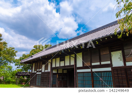 藍天和古老的日式房屋:日式夏日景色,瓦片屋頂和綠植環繞 - 留有文字空間的背景素材。 藍天和古老的日式房屋:日式夏日景色,瓦片屋頂和綠植環繞 - 留有文字空間的背景素材。 142249649