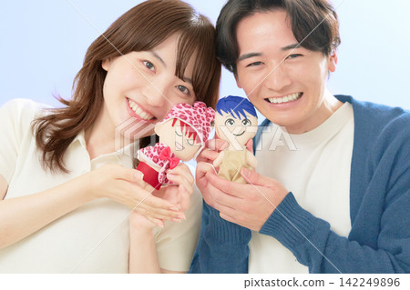 一對年輕男女面帶微笑,手裡拿著他們最喜歡的卡通人物的毛絨玩具。 一對年輕男女面帶微笑,手裡拿著他們最喜歡的卡通人物的毛絨玩具。 142249896