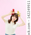 A young woman smiling while holding a stuffed animal. 142249911