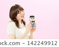 A young woman holding her favorite doll 142249912