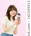 A young woman smiles and shows off her favorite plush toy. 142249913