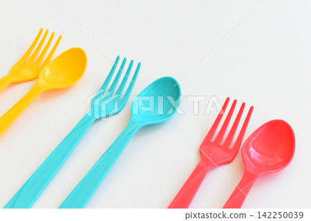 colorful spoon and fork isolated on white background, plastic cutlery for picnic colorful spoon and fork isolated on white background, plastic cutlery for picnic 142250039