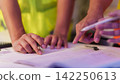 Engineers hands reviewing blueprint on desk for construction project planning 142250613