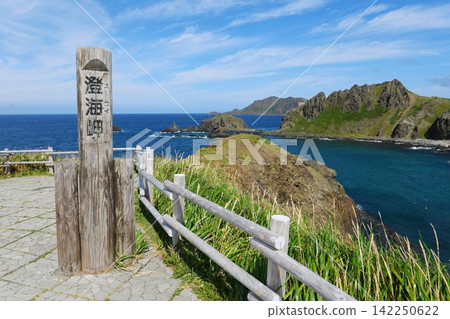 [Rebun Town, Rishiri-Rebun-Sarobetsu National Park: A view of the Sea of Japan coastline beyond a wooden marker post at "Sumikai Cape"] 142250622