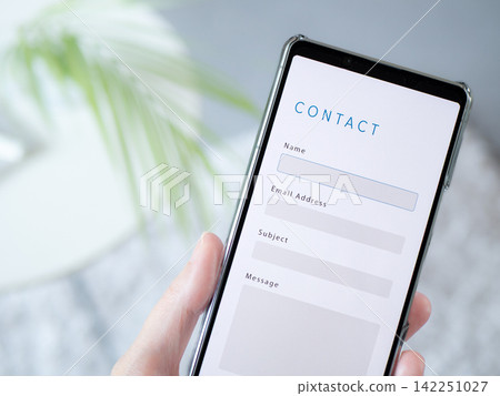 在智慧型手機上顯示的「聯絡我們」表單的網站畫面。 在智慧型手機上顯示的「聯絡我們」表單的網站畫面。 142251027