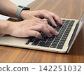 Hand to operate the laptop 142251032