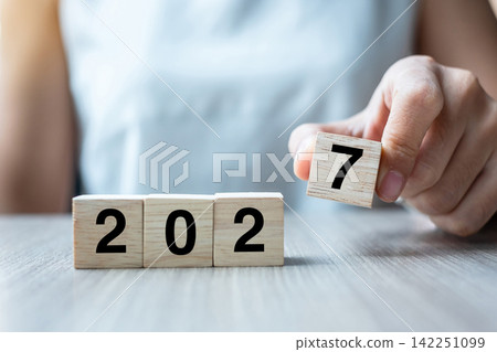 hand flipping block 2026 to 2027 text on table. Resolution, strategy, plan, goal, motivation, reboot, business and New Year holiday concepts hand flipping block 2026 to 2027 text on table. Resolution, strategy, plan, goal, motivation, reboot, business and New Year holiday concepts 142251099