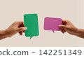Two hands hold colorful blank speech bubbles over a neutral background, symbolizing communication, dialogue 142251349