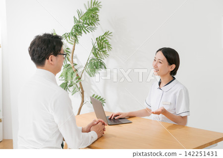 一位診所女接待員和一位男顧客 一位診所女接待員和一位男顧客 142251431