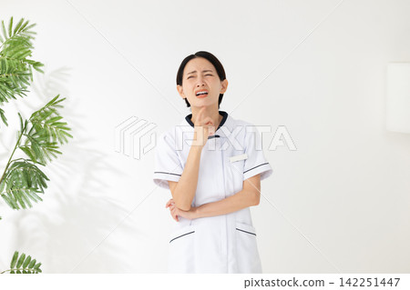 A worried woman in a white coat A worried woman in a white coat 142251447